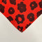 up close of set of two red cloth napkins with black abstract flowers
