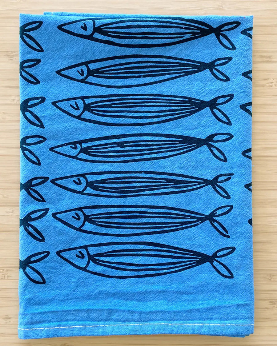 folded blue cotton tea towel with all over sardine print