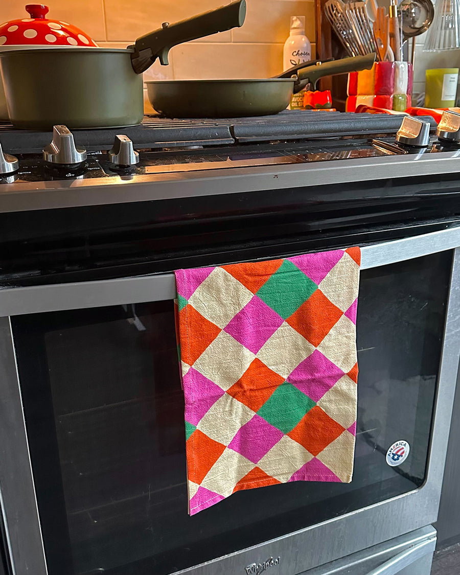 pink, orange, yellow and green diamond tea towel on a oven handle