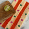 ale yellow and orange striped tea towel with green and pink dots with a cutting board and lime on it