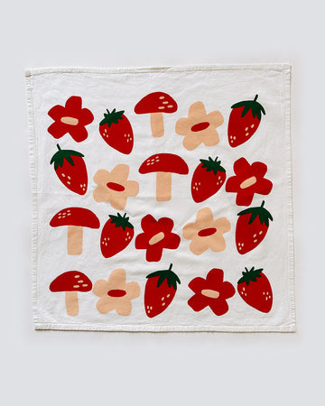 white cotton tea towel with peach and red flowers, red mushrooms and strawberry print