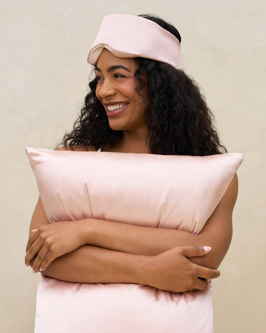 model with pink satin contour pillow eye mask on her forehead