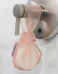 coral conditioner bar bag with bar hanging on shower faucet