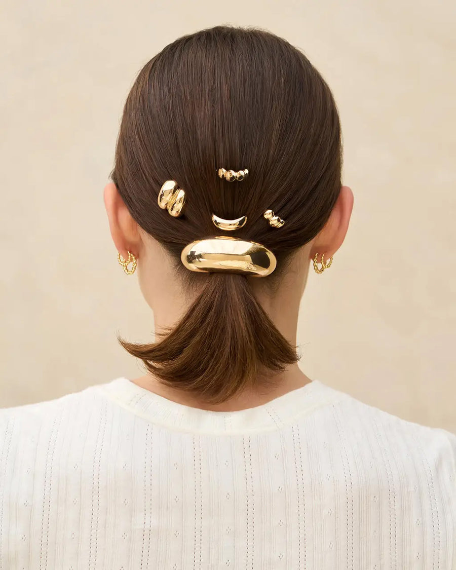 set of three gold metal pony tail pins in models hair