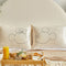 cream silk pillowcase with mickey mouse sketch profile on a bed with the matching minnie pillowcase