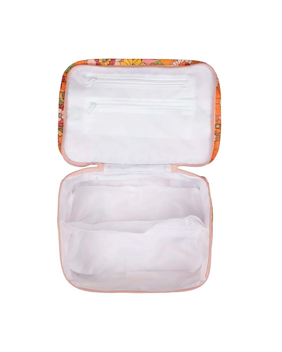 white interior of pink toiletry stash bag with pink, yellow, and orange 70's retro floral print and green strap
