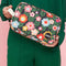 model holding black travel bag with colorful mod floral print