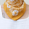 model wearing golden yellow 22 in. x 22 in. square bandana with white floral print around their neck
