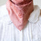 model wearing rose pink 22 in. x 22 in. square bandana with burgundy floral print with knot in the back