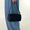 black nylon barrel handbag with leather buckle shoulder strap and trim