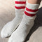 model wearing white crew socks with two red stripes on the top