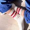 model wearing white crew socks with two red stripes on the top