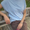 side view of model wearing light blue cap sleeve tee
