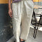model wearing cream pants with workmen patches down the front and inner drawstring