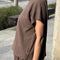 side view of model wearing chocolate relaxed fit cotton tee with muscle type sleeves and side vents