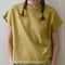 model wearing mustard yellow tee with ringer neckline and muscle tee sleeves