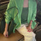 model wearing un-buttoned oversized spring green button down top
