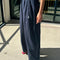 side view of model wearing navy billowy parachute pants