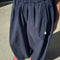 up close of model wearing navy billowy parachute pants