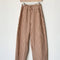 rust and white gingham relaxed fit pants on a hanger