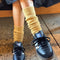 model wearing long mustard socks with sneakers