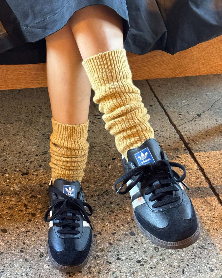 model wearing long mustard socks with sneakers