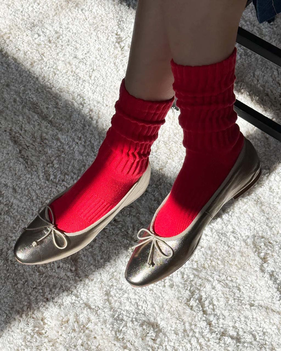 model wearing strawberry red socks with high cuff and silver ballet flats