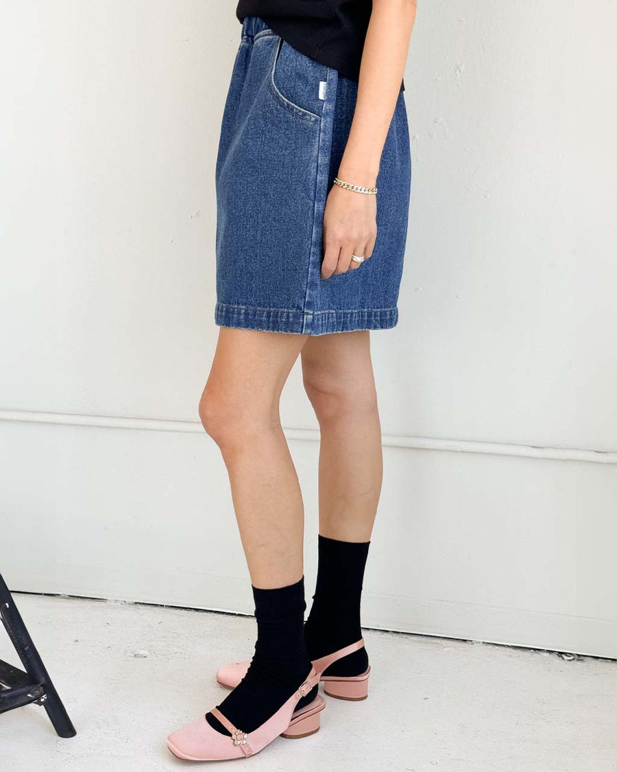 side view of model wearing denim skirt with elastic waist and pockets