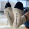 bottom view of model wearing cream crew socks with brown and black trim