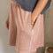 side view of model wearing peach colored cotton shorts