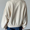 back view of model wearing cream pullover cotton sweatshirt with kangaroo pocket