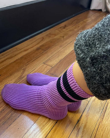 model wearing orchid socks with navy stripes
