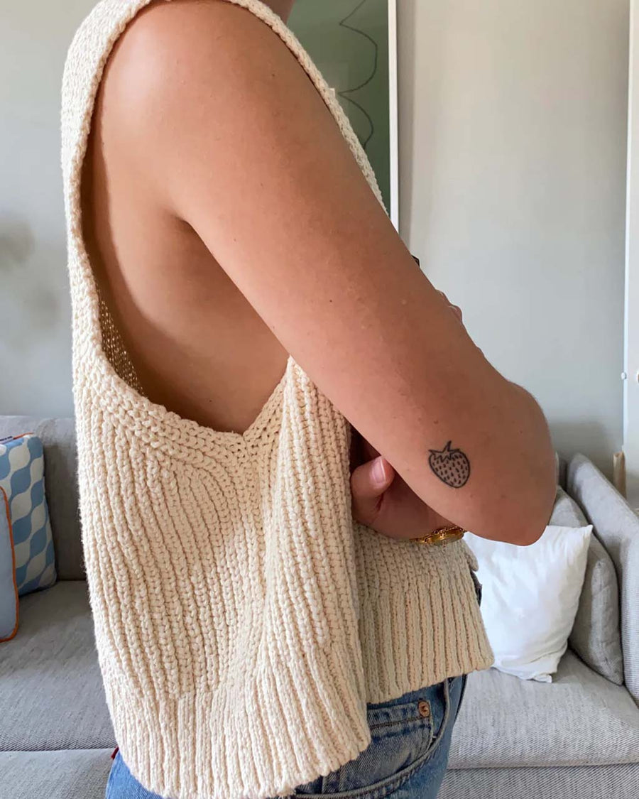 side view of model wearing cream granny sweater vest with open front