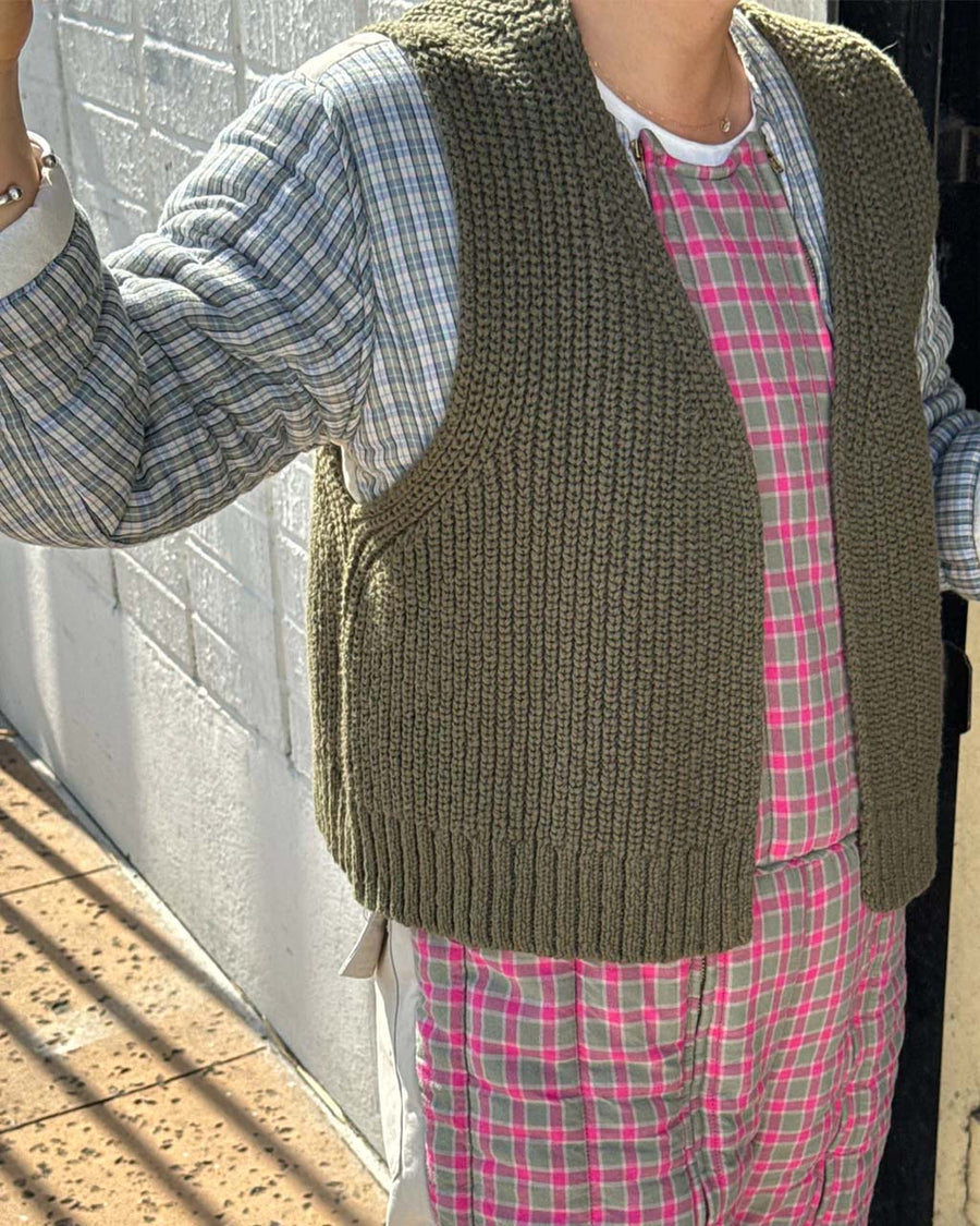 side view of model wearing olive green knit open front sweater vest
