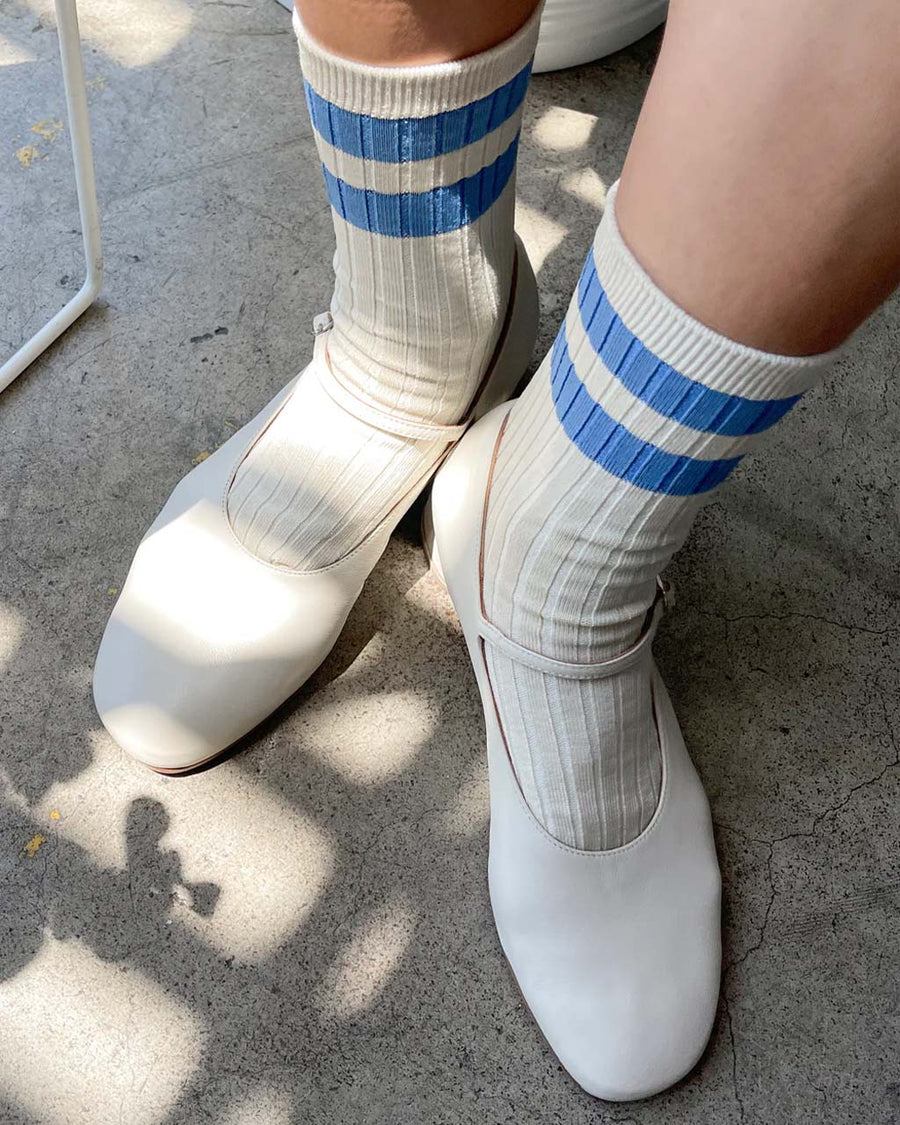 model wearing cream high crew socks with double blue stripes at the top