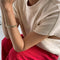 up close of model wearing cream cap sleeve tee with side slits