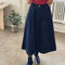 model wearing extended length denim midi skirt with button front and pockets