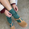model wearing high crew fuzzy emerald socks with brown flats
