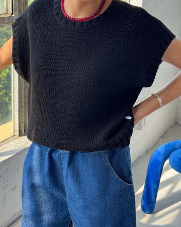 model wearing black short sleeve sweater top with denim