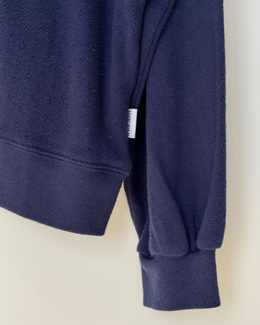 up close of navy pointelle sweatshirt with banded bottom