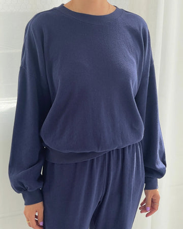 model wearing navy pointelle sweatshirt with banded bottom