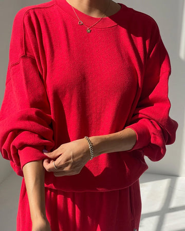 model wearing candy apple red pointelle sweatshirt with banded bottom
