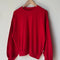 candy apple red pointelle sweatshirt with banded bottom on a hanger