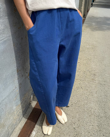 model wearing blue azure arc pants with side pockets and side leg panels
