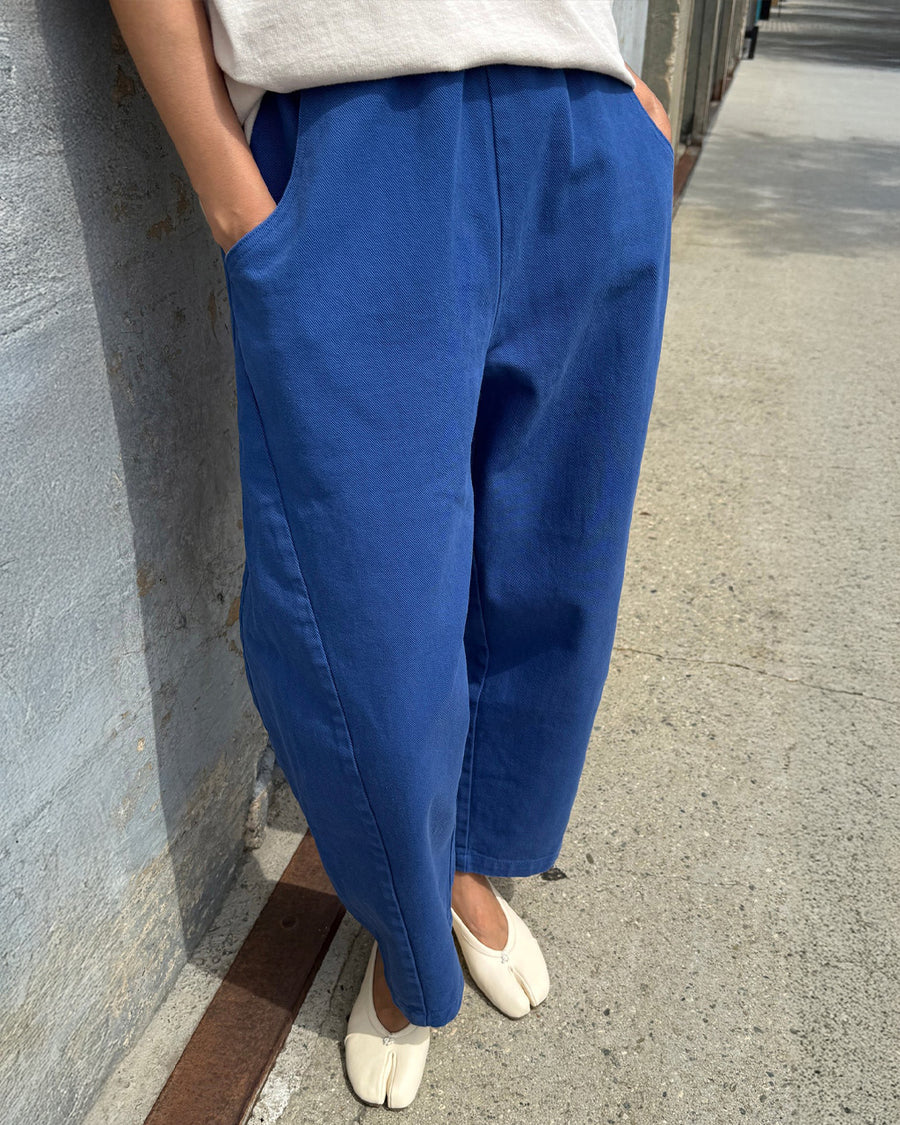 model wearing blue azure arc pants with side pockets and side leg panels