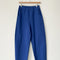 blue azure arc pants with side pockets and side leg panels on a hanger