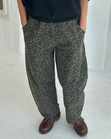 model wearing greenish leopard print arc pants with side pockets and side leg panels