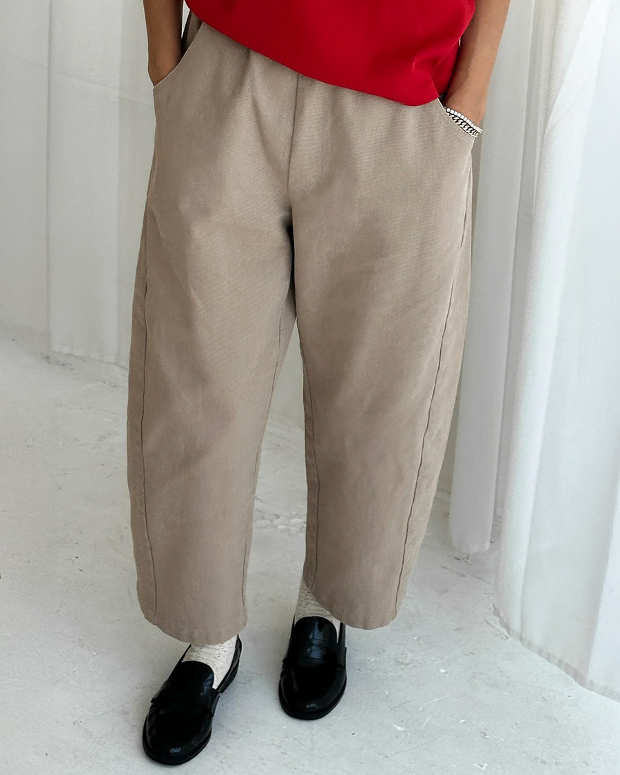 model wearing khaki arc pants with side pockets and side leg panels