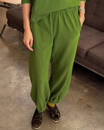 model wearing avocado green cotton balloon pants with side pockets