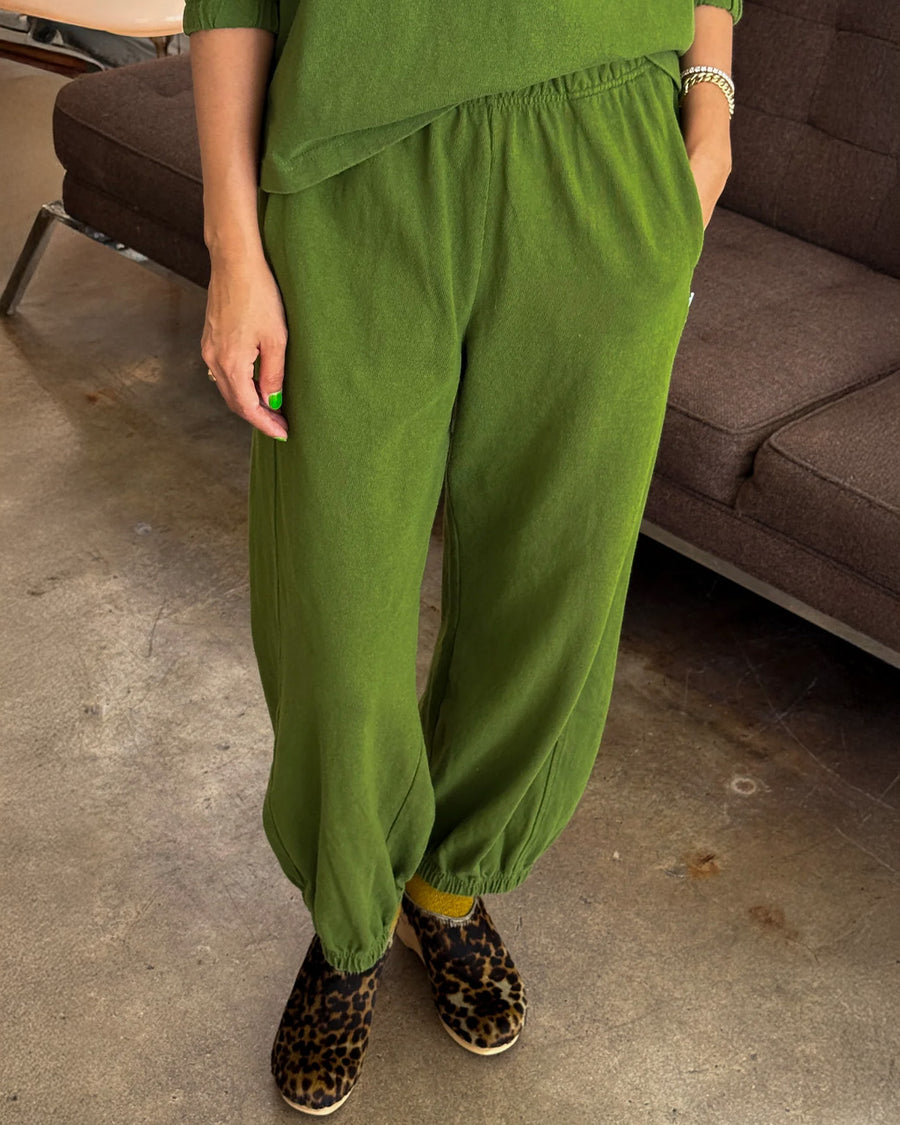 model wearing avocado green cotton balloon pants with side pockets